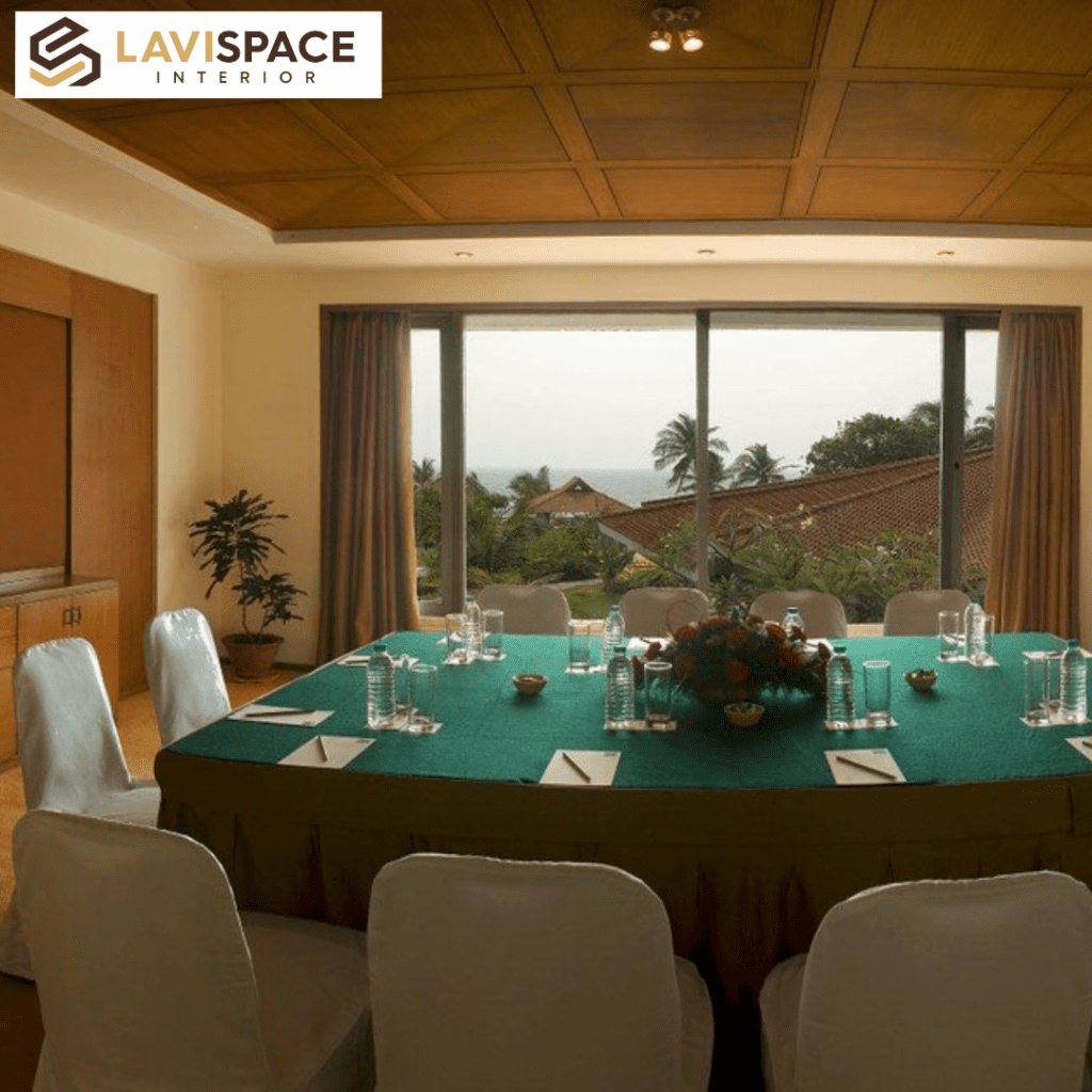 Elegant conference room with a large window, green tablecloth, and white chairs.